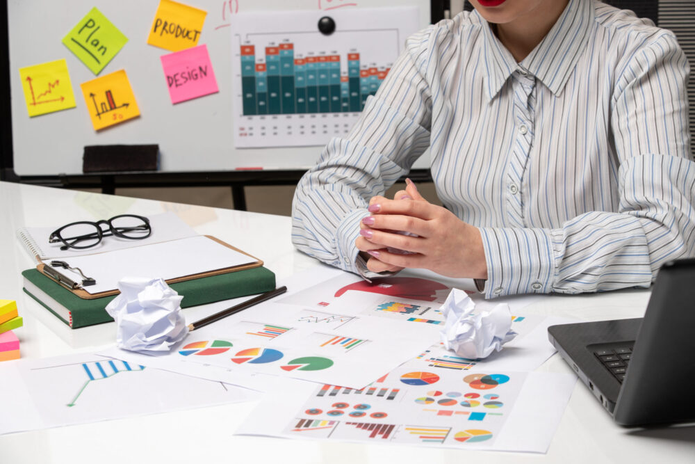 person in front of desk papers reports